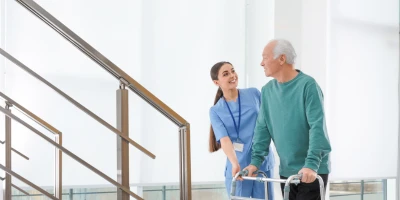 nurse and an elderly man with a walker