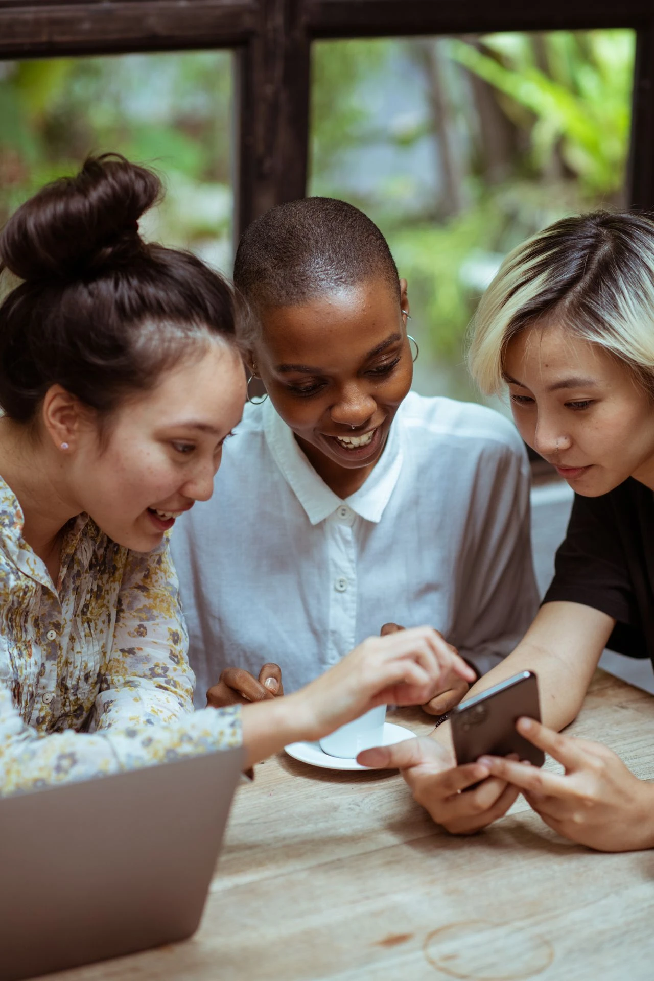 three women looking at something on a phone